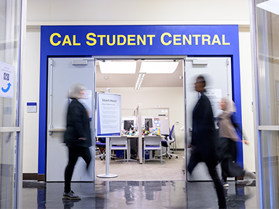 People walking by the Cal Student Central entrance sign